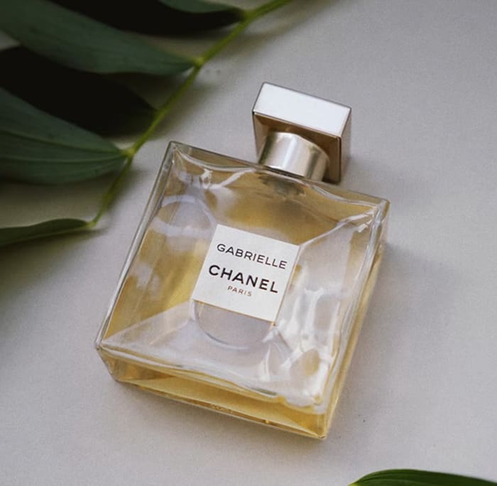 a bottle of perfume with leaves around